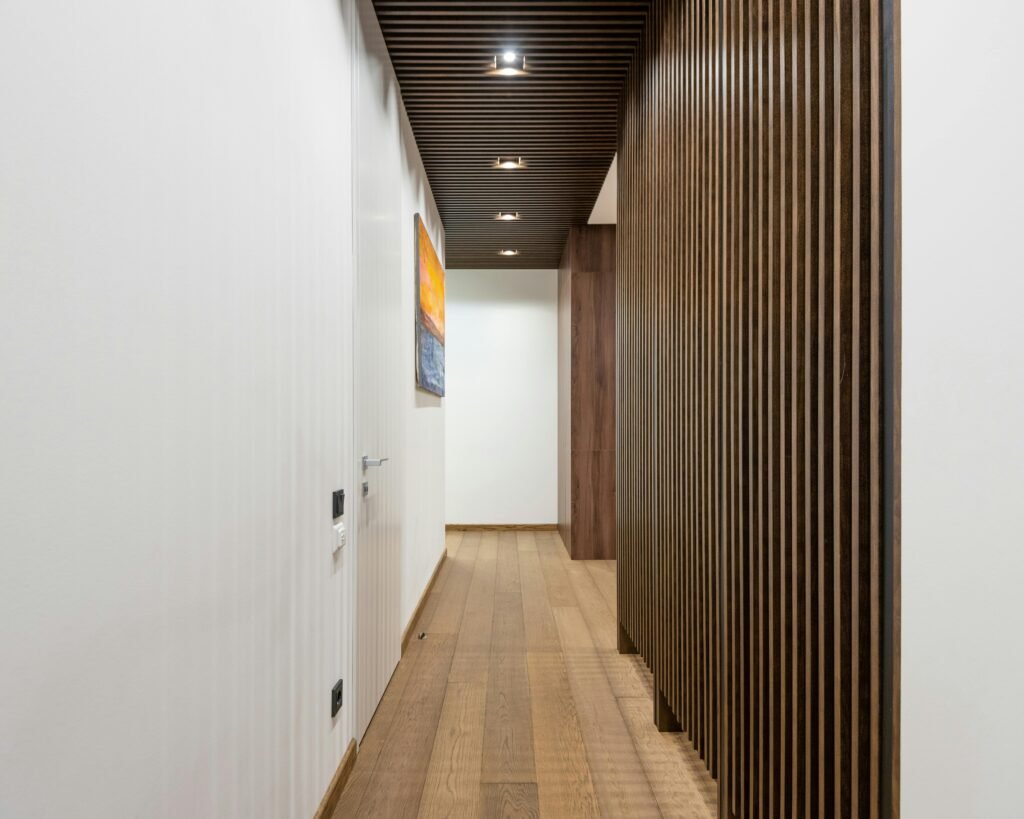 A sleek, contemporary hallway featuring wood paneling and modern lighting fixtures.